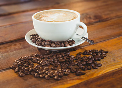 Cup of coffee with coffee beans on a wooden table