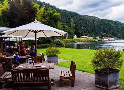 Outside tables and chairs at Lakeland Restaurant Tokaanu looking across Lake Taupo to Waihi Village