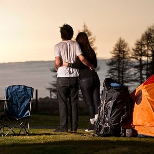 A couple with their arms around each other at their Discovery Lodge tent site