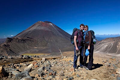 A couple standing together on the Tongariro Alpine Crossing with Mt Ngauruhoe in the background