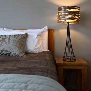 Superior quality bed and hand made cabbage tree leaves lamp shade inside chalet studio at Discovery Lodge Tongariro