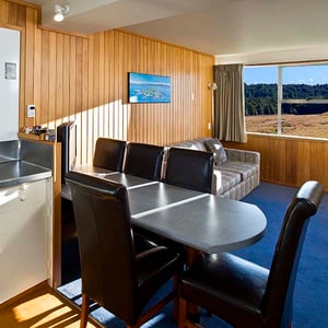 Kitchen, dinning table, sofa and alpine meadow views from motel one bedroom at Discovery Lodge Tongariro National Park