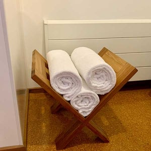 Rolled bathroom towels and radiator heater in a Discovery Lodge Tongariro bathroom