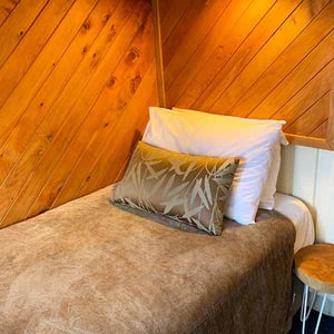 Discovery Lodge Twin room bedding with wood interior