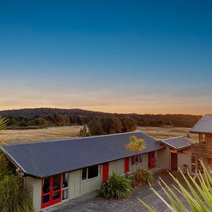 Discovery Lodge Twin Room Exterior with alpine meadows and beach forest in the background