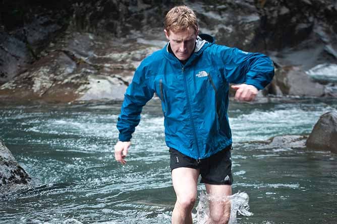 Callum Harland, owner of Discovery Lodge crossing a mountain stream in the Tongariro National Park