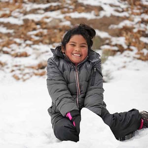 A young girl playing in the snow