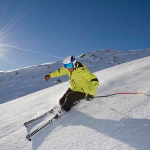 Skier with sunshine and blue ski