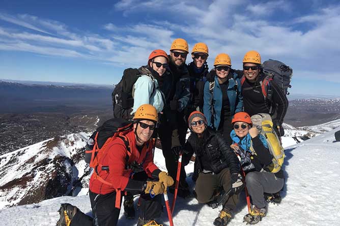 A group of hikers enjoying the snow on the Tongariro Alpine Crossing in winter